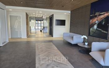 Stylish reception area at Noorderpoort 33 33, Venlo, featuring modern seating and a sleek design. Ideal for office space rental, this inviting space has a contemporary touch with wooden accents.