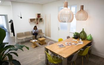 Office space rental at Kaldenkerkerweg 56 in Venlo, featuring a modern lounge area with wooden table, colorful chairs, and cozy seating.