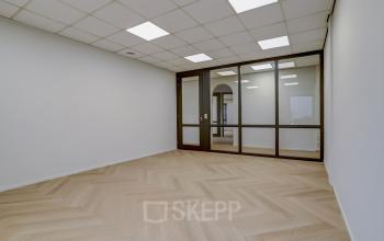 Spacious and well-lit office interior at Keizersveld 47 47 in Venray, featuring sleek glass partitions and elegant flooring, ideal for office space rental.