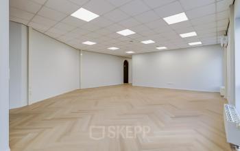 Spacious and bright office space with herringbone flooring and modern lighting at Keizersveld 47 47, Venray, available for rent. Ideal for businesses seeking an open floorplan for dynamic activities.