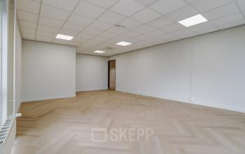 Spacious, unfurnished office space with herringbone wood flooring and white walls at Keizersveld 47 47, Venray, available for office space rental.