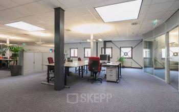 Spacious office area at Kennedyplein 18, Venray with multiple desks, chairs, and large windows. Ideal for office space rental.