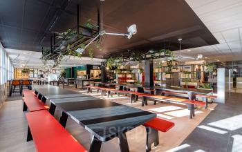 Spacious and modern office interior at Lange Dreef 10, Vianen Utr, featuring sleek black tables with red benches, ideal for open floorplan office space rental.