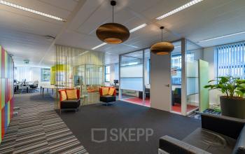 Modern furnished office space rental at Lange Dreef 10, Vianen Utr. Features colorful partitions, lounge seating, and ample natural light, ideal for creative collaboration.