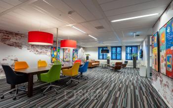 Colorful conference room at Lange Dreef 10, Vianen Utr with bright chairs, vibrant wall art, and modern lighting, perfect for office space rental.