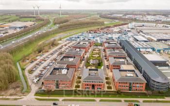 Aerial view of office buildings at Lange Dreef 17, Vianen Utr, surrounded by parking spaces and greenery. Ideal for office space rental with excellent accessibility. Industrial setting with nearby facilities.