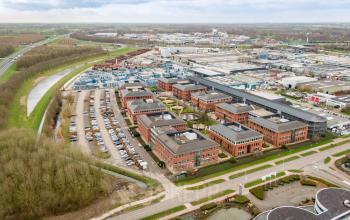 Aerial view of an office space at Lange Dreef 17, Vianen Utr, showing a cluster of brick buildings surrounded by parking areas and greenery, ideal for office space rental.