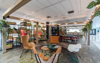 Modern, open workspace at Lange Dreef 17, Vianen Utr, featuring stylish seating and vibrant greenery. Ideal for office space rental. The environment is designed for creativity and collaboration.