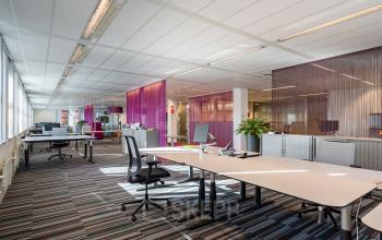 Modern office space at Lange Dreef 17, Vianen Utr, featuring an open floor plan with desks, chairs, and vibrant partitions, ideal for office space rental.