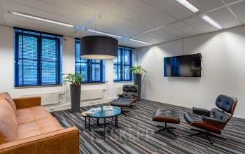 Modern office lounge at Lange Dreef 17 in Vianen Utr, featuring stylish seating, a large TV, and bright natural light. Discover office space rental with a contemporary touch.
