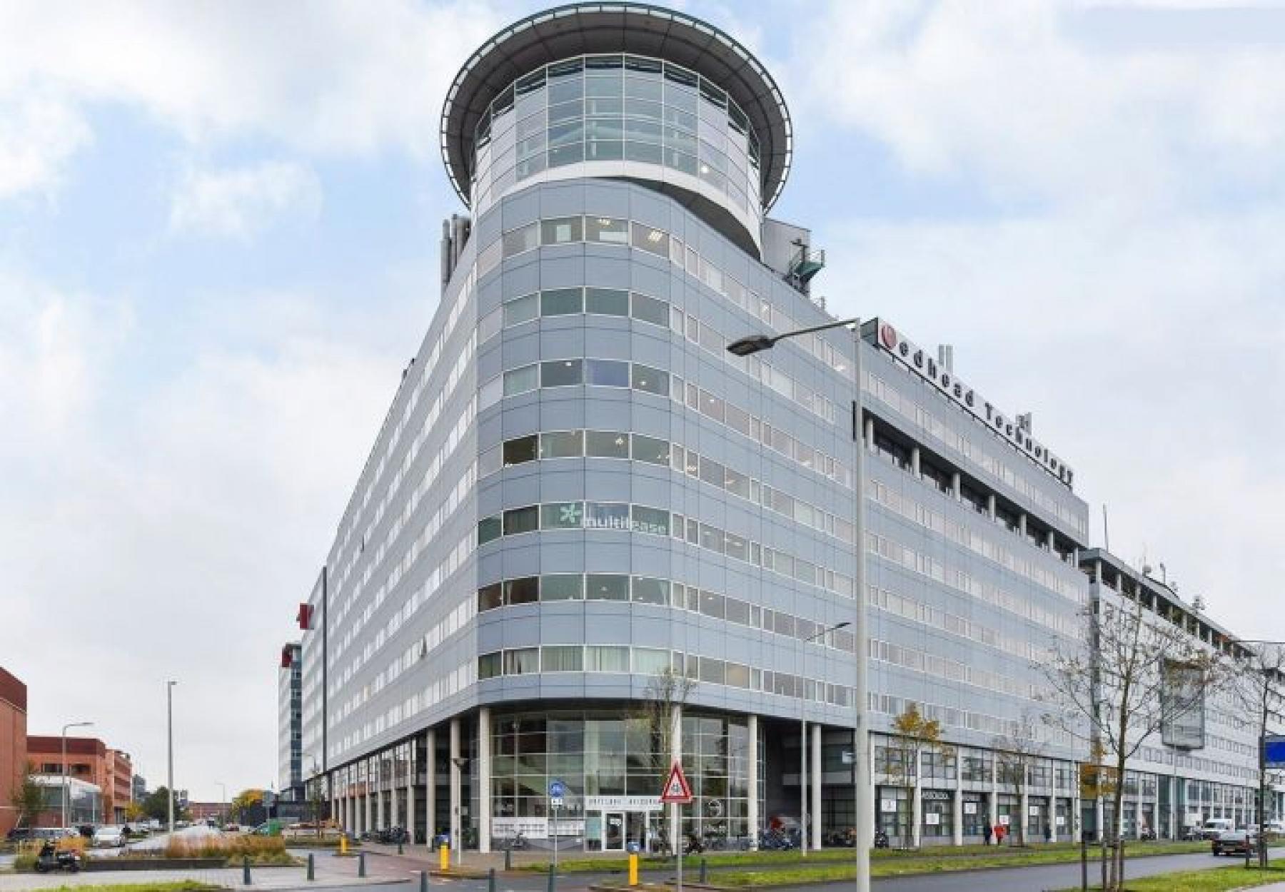 Exterior view of the modern office building at Regulusweg 11, Voorburg, featuring large windows and a sleek design. Ideal for businesses seeking office space rental in a prominent location.