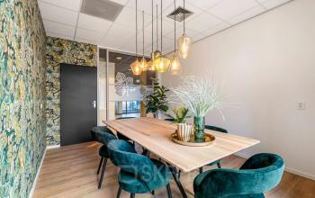 Stylishly furnished office space at Agro Business Park 22, Wageningen, ideal for rent. Features a modern table with chairs and decorative lighting, perfect for meetings.
