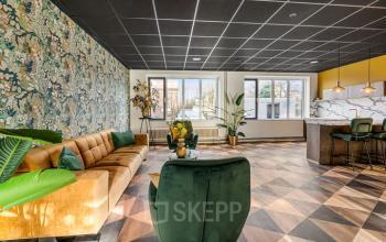 Spacious, well-lit furnished office to rent at Agro Business Park 22, Wageningen, featuring stylish seating and vibrant decor for a comfortable workspace atmosphere.