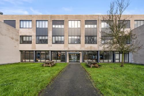 Exterior view of the office building at Agro Business Park 22, Wageningen, featuring a pathway leading to the entrance, ideal for office space rental.