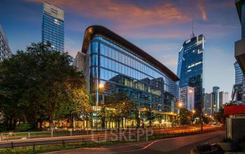 Nowoczesne biura na wynajem w centrum Warszawy Śródmieście, Grzybowska 5a, z przeszkloną fasadą odbijającą światła miasta