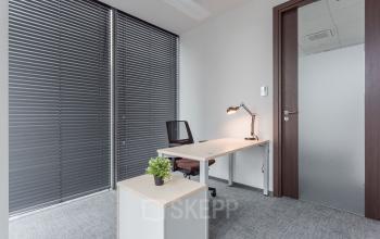 Funkcjonalne i dobrze oświetlone biuro na wynajem na Jana Pawła II 22 w Warszawa Śródmieście z nowoczesnym biurkiem i wygodnym fotelem.