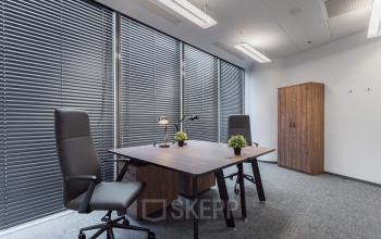 Nowoczesne i przestronne biuro na wynajem przy Jana Pawła II 22 w Warszawa Śródmieście z eleganckim biurkiem, wygodnym fotelem i dużymi oknami.