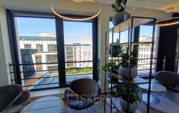 Zmodernizowane biura na wynajem, Zajęcza 15, Warszawa Śródmieście, z eleganckimi fotelami i dużymi oknami z widokiem na miasto.