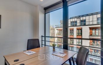 Nowoczesne powierzchnie biurowe przy Zajęcza 15 w Warszawa Śródmieście, wyposażone w elegancki stół i krzesła z widokiem na miasto.