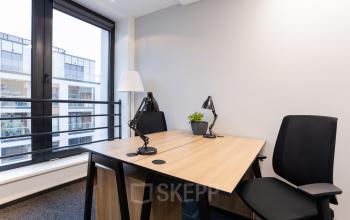 Eleganckie powierzchnie biurowe przy Zajęcza 15, Warszawa Śródmieście z dużym biurkiem i nowoczesnym oświetleniem.