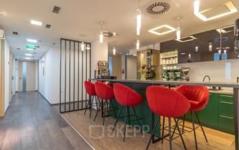 Nowoczesne powierzchnie biurowe na wynajem w Warszawa Śródmieście przy Zajęcza 15 z funkcjonalnym barkiem i wygodnymi czerwonymi krzesłami.