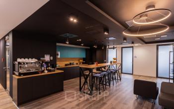 Przestronne powierzchnie biurowe na wynajem na zdjęciu z Zajęcza 15, Warszawa Śródmieście, z elegancką strefą kuchenną i miejscem do odpoczynku.