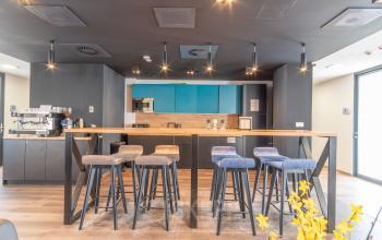 Nowoczesne powierzchnie biurowe na wynajem w Warszawa Śródmieście przy ulicy Zajęcza 15, z wyspą kuchenną, stołkami barowymi i eleganckim wykończeniem