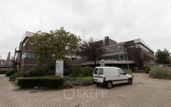 Modern office space rental at Houttuinlaan 4, Woerden, featuring an external view of the multi-story building with surrounding greenery.
