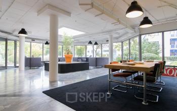 Spacious and modern office space rental at Houttuinlaan 4, Woerden, featuring a large table, comfortable seating, and stylish lighting.