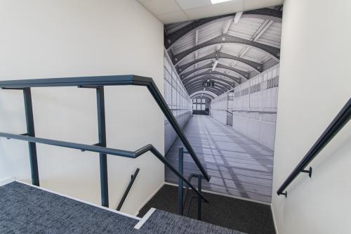 Modern staircase inside Woerden office space rental at Houttuinlaan 4, featuring industrial-style decor.