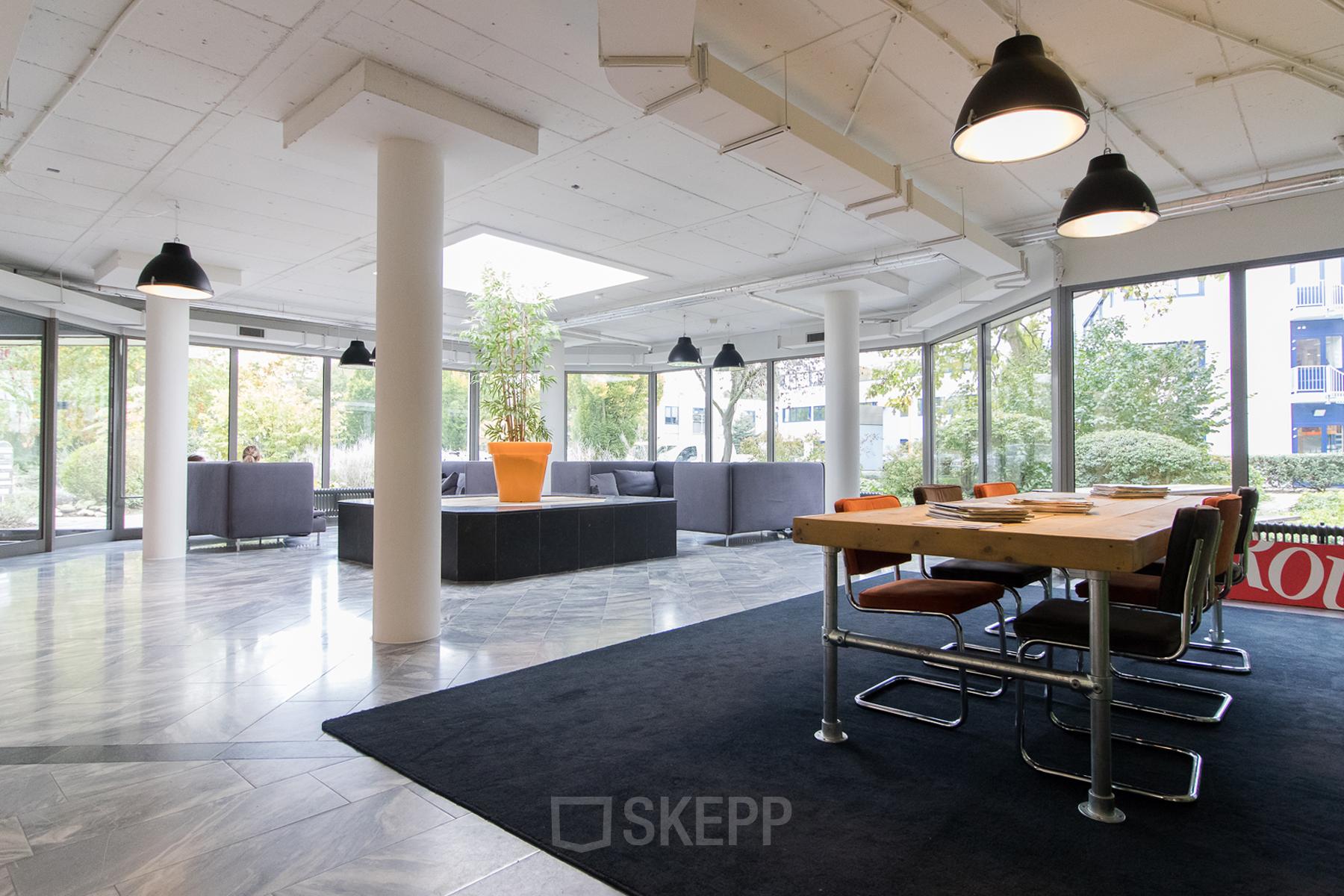 Spacious and modern office space rental at Houttuinlaan 4, Woerden, featuring a large table, comfortable seating, and stylish lighting.