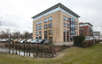 Exterior view of office building at Vijzelmolenlaan 20-26, Woerden with parking area in front.