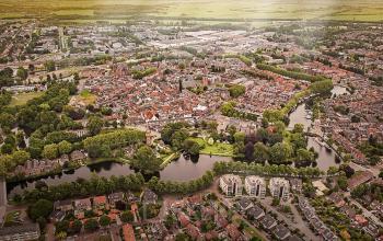 Aerial view of the office building at Vijzelmolenlaan 20-26 in Woerden, surrounded by greenery and urban landscape. Ideal for office space rental.