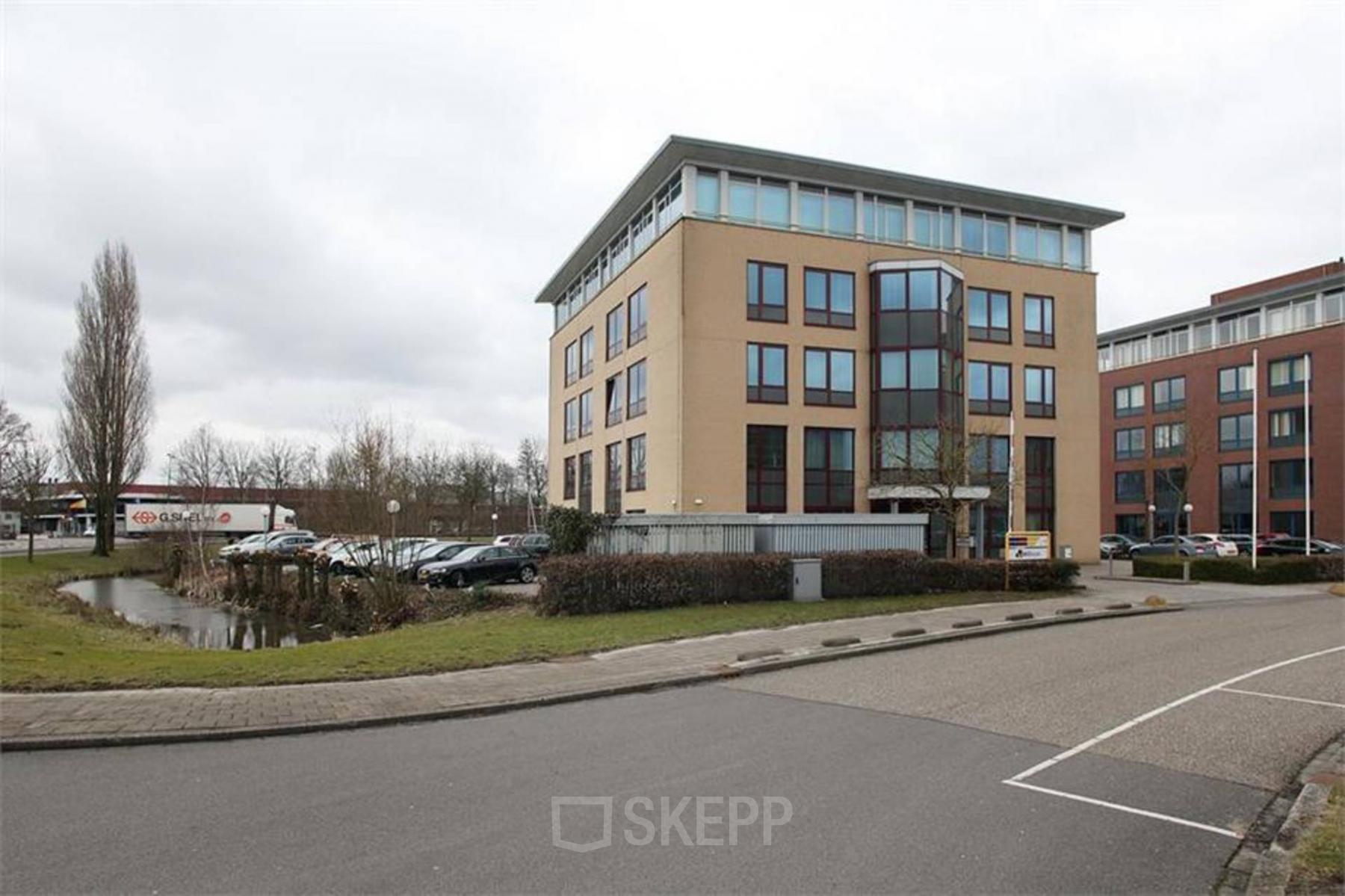 Four-story office building located at Vijzelmolenlaan 20-26, Woerden, available for office space rental. The exterior features modern architecture and ample parking space.
