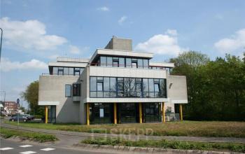 Modern Woerden office space rental at Lindenhof 7 with a large window facade and welcoming yellow accents.