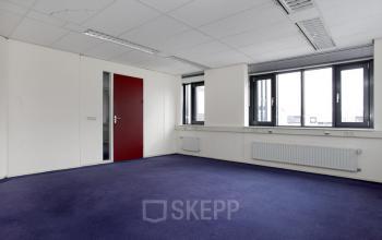 Office space with blue carpet, large windows, and white walls located at Pelmolenlaan 17A, in Woerden.
