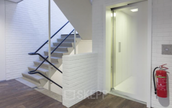 Modern office space rental at Pompmolenlaan 9, Woerden featuring a clean design with elevator and staircase for easy access.