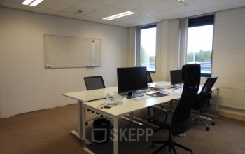 Contemporary office space rental at Pompmolenlaan 9, Woerden, featuring a well-equipped workspace with desks, chairs, and a whiteboard.