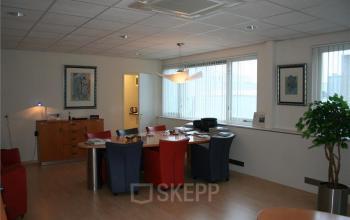 Modern office space rental at Touwslagersweg 6, Woerden, featuring a well-equipped interior with colorful chairs and desks, and tasteful art on the walls.