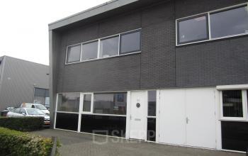 Exterior view of the office building located at Touwslagersweg 6, Woerden, showcasing the entrance and large windows.