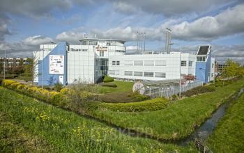 Modern office space rental at Korenmolenlaan 4 in Woerden with a contemporary white exterior and lush green surroundings.