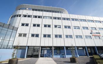 Modern office space rental at Korenmolenlaan 4 in Woerden with a sleek white facade and expansive windows.