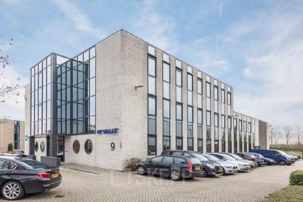 Exterior view of a modern office building at Pompmolenlaan 9, Woerden, offering office space rental with ample parking.