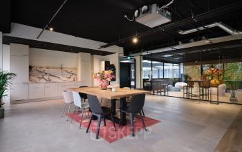 Spacious and modern office space available for rent at Vijzelmolenlaan 9, Woerden, featuring a sleek workspace and dining area with contemporary decor and natural lighting.