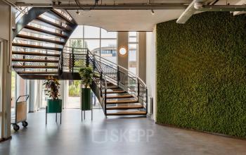 Bright office space with a spiral staircase and a green vertical wall at Vijzelmolenlaan 9, Woerden, available for rent.
