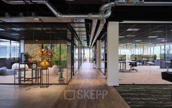 Modern office with glass partitions at Vijzelmolenlaan 9, Woerden. Ideal for office space rental with sleek design elements and workspaces visible through transparent walls.