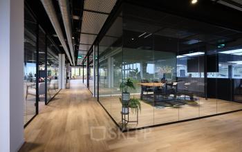 Modern office space rental with glass-walled conference room and sleek furnishings at Vijzelmolenlaan 9, Woerden.