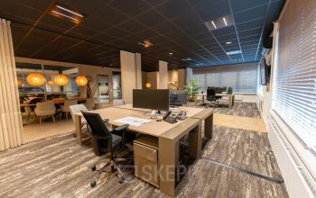 Modern office space with large desks and chairs, computer monitors, and warm lighting at Vijzelmolenlaan 9, Woerden, ideal for rent office space.