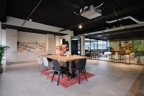 Spacious and modern office space available for rent at Vijzelmolenlaan 9, Woerden, featuring a sleek workspace and dining area with contemporary decor and natural lighting.