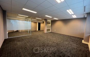 Spacious, carpeted office area with glass-walled section at Zaagmolenlaan 4, Woerden, available for office space rental.